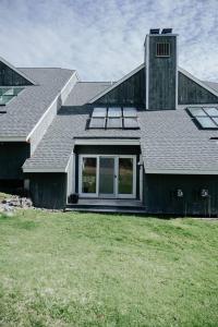 a house with a gambrel roof on top of a yard at NEW! Townhouse - Tenney Mountain Resort in Plymouth