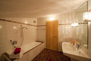 a bathroom with a shower and a tub and a sink at Appartementhaus Leitner in Ehrwald +24 photos