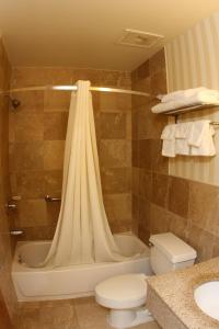 a bathroom with a tub and a toilet and a sink at Super 8 by Wyndham Kutztown/Allentown Area in Kutztown