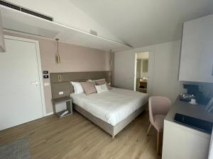 - une chambre avec un lit blanc et une chaise dans l'établissement Chic & Charme Luxury Rooms, à Olbia