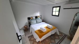 ein Schlafzimmer mit einem Bett mit zwei Handtüchern darauf in der Unterkunft Le Ptit Gibs in Petit-Bourg