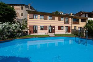 a large swimming pool in front of a house at Agriturismo El Crear in San Pietro in Cariano