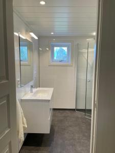 ein weißes Badezimmer mit einem Waschbecken und einem Spiegel in der Unterkunft Aurland Feriehus in Aurland