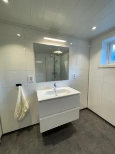 Aurland Feriehus في أرلاند: حمام أبيض مع حوض ومرآة