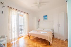 a white bedroom with a bed and a window at Plaza 2 in Sveti Juraj