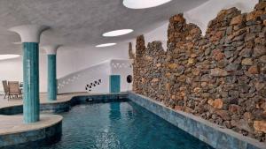 a indoor swimming pool with a stone wall at Complejo Gaviotas Beach Golf in Almerimar