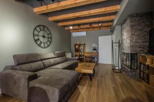 a living room with a couch and a clock on the wall at Monte Bella in Žabljak