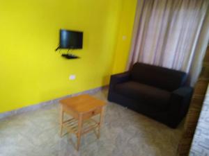 sala de estar con sofá negro y mesa en Abokobi Cosy Home, en Accra