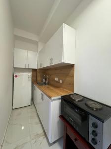a kitchen with white cabinets and a sink and a stove at D&M Apartments in Struga