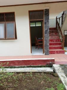 バンドンにあるKost Omayaの階段に赤い敷物が敷かれた家