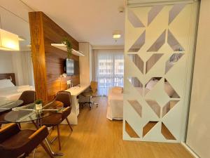 a room with a table and a bed and a desk at BSB Stay Flats Particulares - SHN in Brasilia