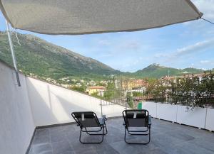 - deux chaises sur un balcon avec vue sur la montagne dans l'établissement Alla Posta Matrimoniale Relax, à Posta Fibreno