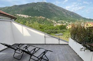2 sillas sentadas en un balcón con una montaña en Alla Posta Matrimoniale Relax, en Posta Fibreno