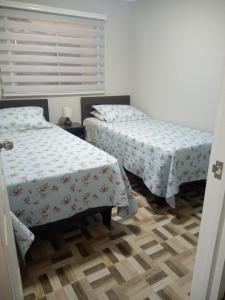 a bedroom with two beds and a window at departamentos mirador 2 piso in Caldera