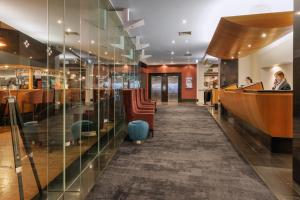 een restaurant met een bar met glazen wanden bij Hotel Grand Chancellor Melbourne in Melbourne