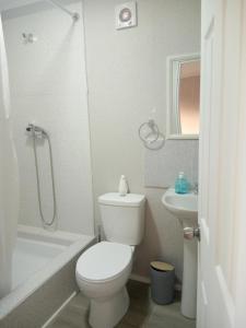 uma casa de banho branca com um WC e um lavatório em departamentos mirador 2 piso em Caldera