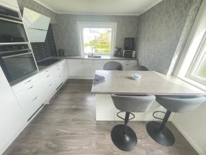 a kitchen with white cabinets and a table and chairs at Åndalsnes Luxury Stay - Full Apartment in Åndalsnes