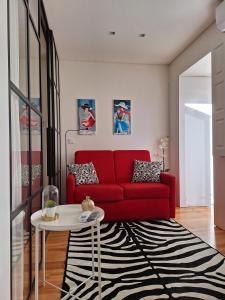 a living room with a red couch and a black and white rug at 4PortoApartments#2 in Porto