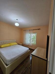 a bedroom with a large bed and a window at Villa Dario in Vlorë
