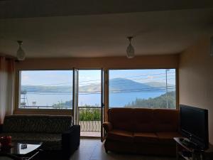 a living room with a couch and a large window at Villa Dario in Vlorë
