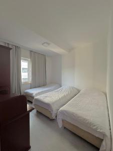 - une chambre avec 2 lits et une fenêtre dans l'établissement M&D Apartment, à Struga