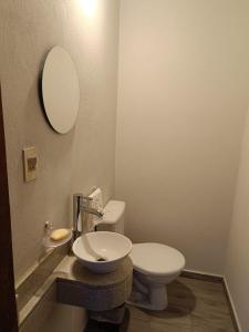 bagno con servizi igienici, lavandino e specchio di "La serena" a Luque