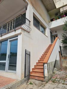 a white house with stairs and a balcony at Villa Dario in Vlorë +3 photos