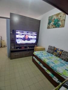 a bedroom with a bed and a flat screen tv at Praia Guilhermina Sol Mar in Praia Grande