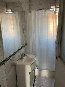 y baño blanco con lavabo y ducha. en Casa Blanca, en Santiago