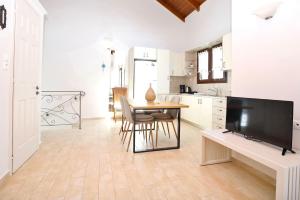 a kitchen with a table and a tv in a room at Kores Villas in Nydri