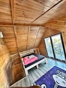 a bedroom in a log cabin with a bed in it at Sosenkowe Zacisze Wiele in Wiele