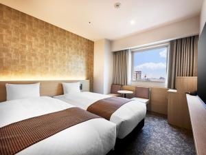 Un pat sau paturi într-o cameră la Daiwa Roynet Hotel Gifu