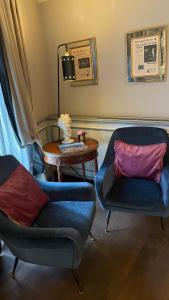 een woonkamer met 2 stoelen en een tafel bij Il Relais in Verona