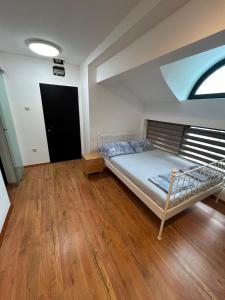a bedroom with a bed in a room with wood floors at Apartments Iva in Kragujevac