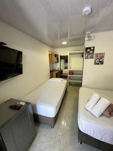 a hotel room with two beds and a flat screen tv at Alojamiento turístico Keniant's in San Andrés