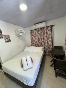 1 dormitorio con 1 cama con toallas en Alojamiento turístico Keniant's en San Andrés
