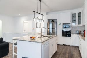 una cucina con mobili bianchi e un piano di lavoro di Incense a Água de Alto