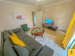 a living room with a couch and a table at GoldenWays Apartment 3 in Mbabane