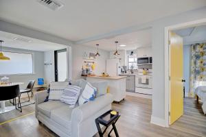 een woonkamer en een keuken met een bank en een tafel bij Chic Retreat with Cozy Fire Pit in Sebring