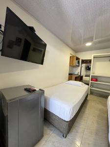 a bedroom with a bed and a flat screen tv at Alojamiento turístico Keniant's in San Andrés