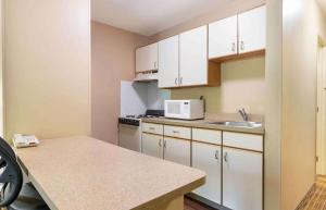 a small kitchen with white cabinets and a sink at Extended Stay America Select Suites - Columbia - Gateway Drive in Columbia