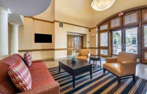 ein Wohnzimmer mit einem Sofa, Stühlen und einem Tisch in der Unterkunft Extended Stay America Suites - Orlando - Maitland - Summit Tower Blvd in Orlando