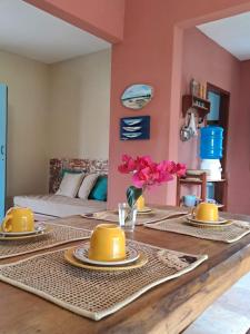 ein Esszimmer mit einem Tisch, auf dem gelbes Geschirr steht in der Unterkunft Casa Sofia - Macapá Paradise in Luis Correia