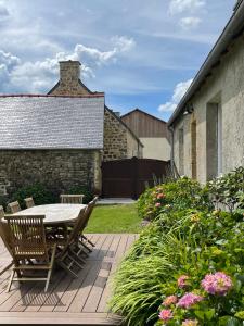 a patio with a table and chairs on a deck at Les Cottages du Manoir, Jacuzzi -Crozon in Crozon