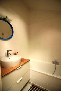 uma casa de banho com um lavatório, um espelho e uma banheira em Bright studio near Nato em Bruxelas