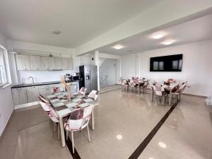 a dining room with tables and chairs and a kitchen at Christale Rooms in Năvodari
