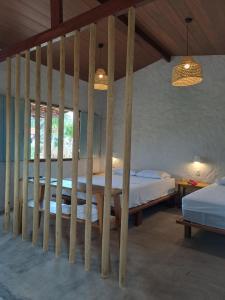 ein Schlafzimmer mit einem Bett mit einem Bettrahmen aus Holz in der Unterkunft Casa Carol - Macapá Paradise in Luis Correia