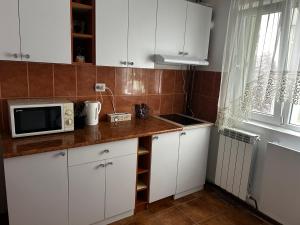 a kitchen with white cabinets and a microwave at Elina apartament in Drobeta-Turnu Severin