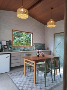 a kitchen with a wooden table and chairs at Casa Carol - Macapá Paradise in Luis Correia