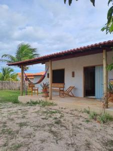 ein Haus mit einer Hängematte davor in der Unterkunft Casa Carol - Macapá Paradise in Luis Correia